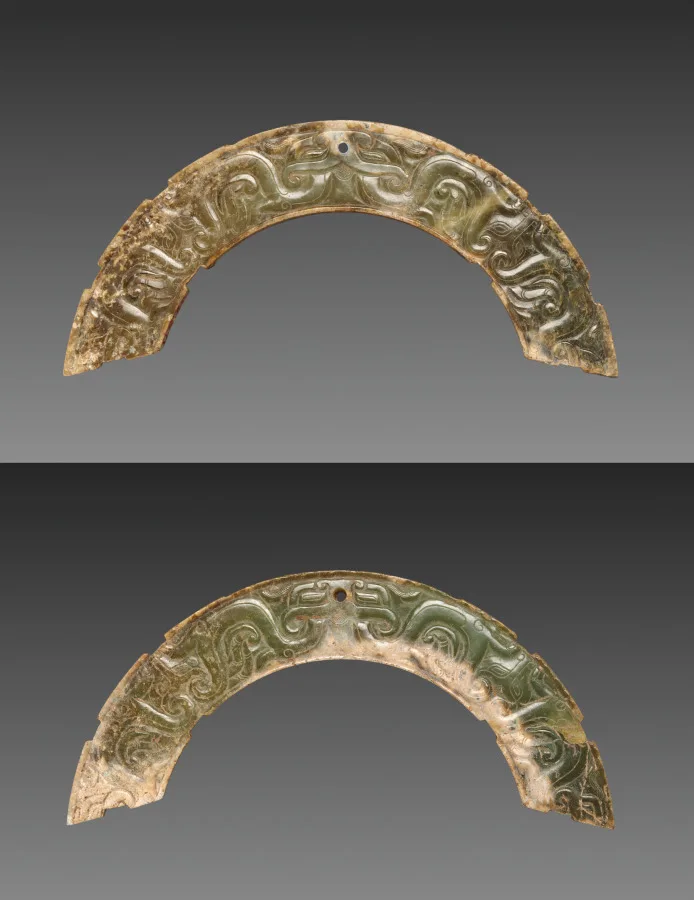 Two matching arc-shaped nephrite pendants, each carved with an animal mask and interlaced scrolls