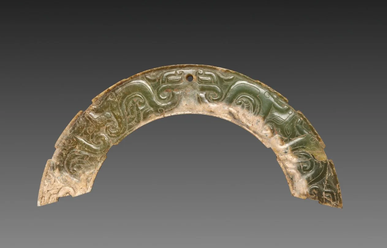 Arc-shaped nephrite pendant with carved animal mask and interlaced scroll pattern