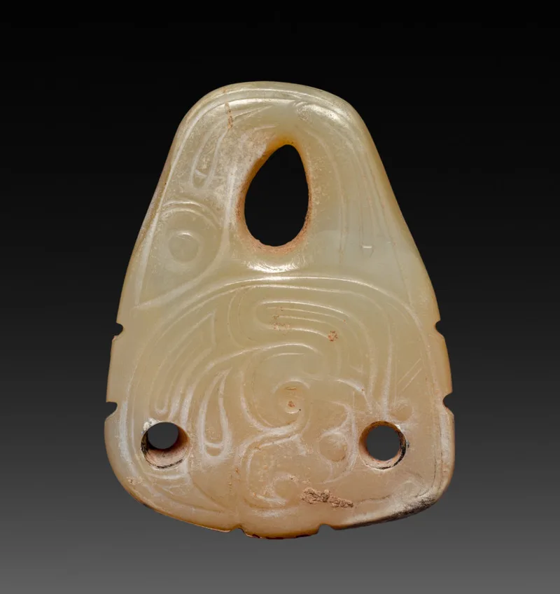Nephrite pendant carved with a coiled dragon and a fish in low relief