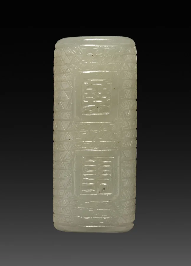Small drilled jade bead with carved surface