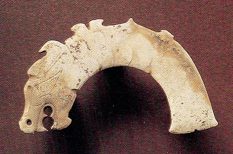Jade (nephrite) pendant, in the shape of an animal with fish tail, shang and zhou dynasties, 8.3 cm wide.