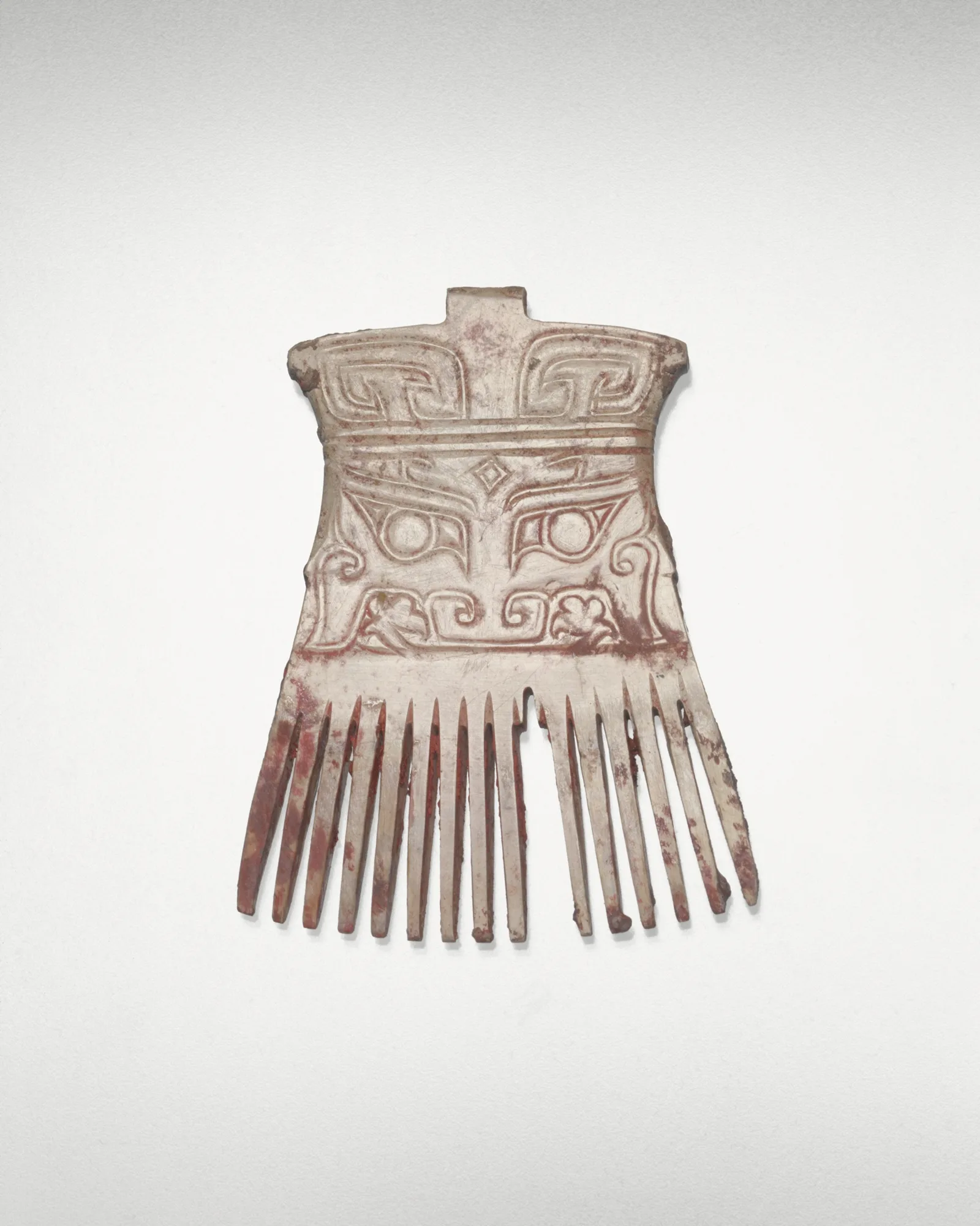 Jade (nephrite) and cinnabar comb, shang and zhou dynasties, 7.6 cm high.