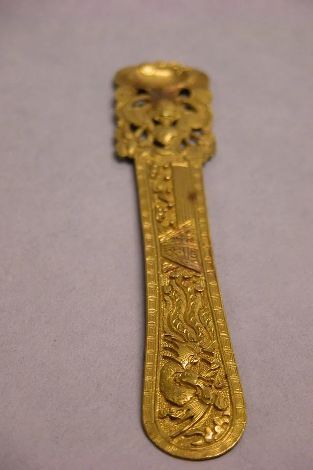 Gold hairpin with a short decorative head and a single tapering shaft, Ming dynasty
