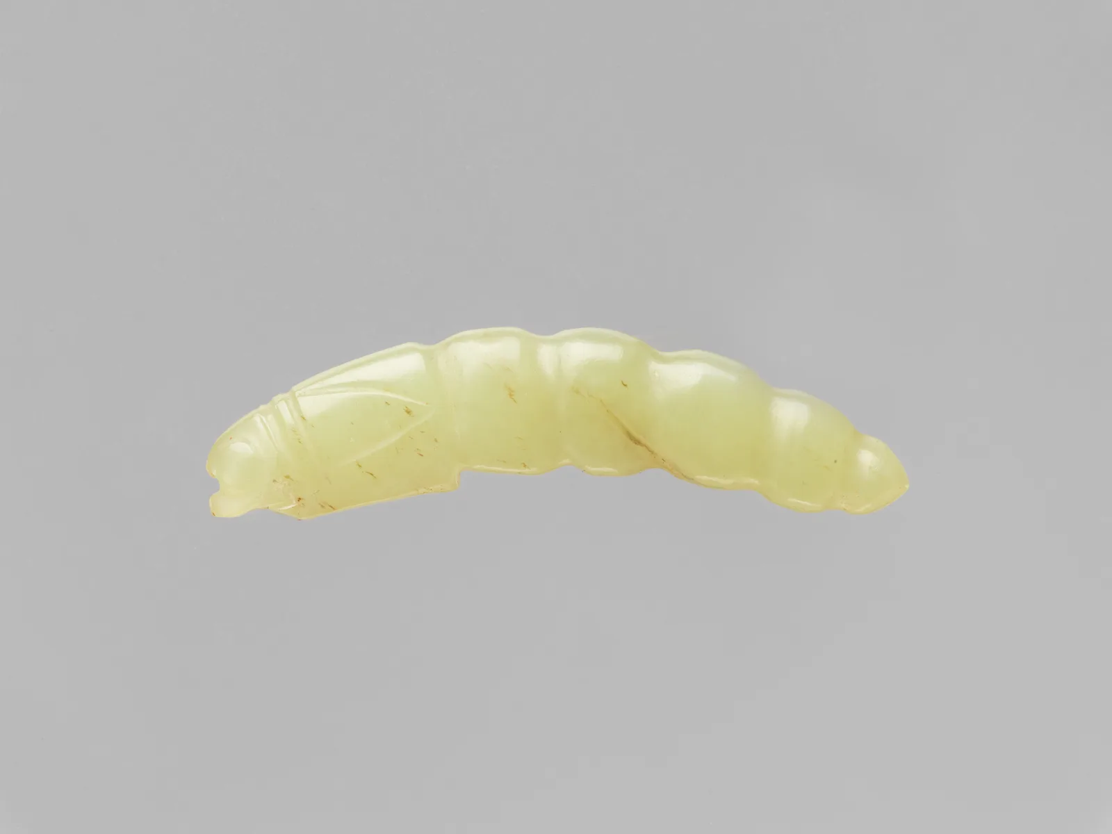 Jade (nephrite) pendant, in the shape of a silk worm, shang and zhou dynasties, 4.8 cm long.